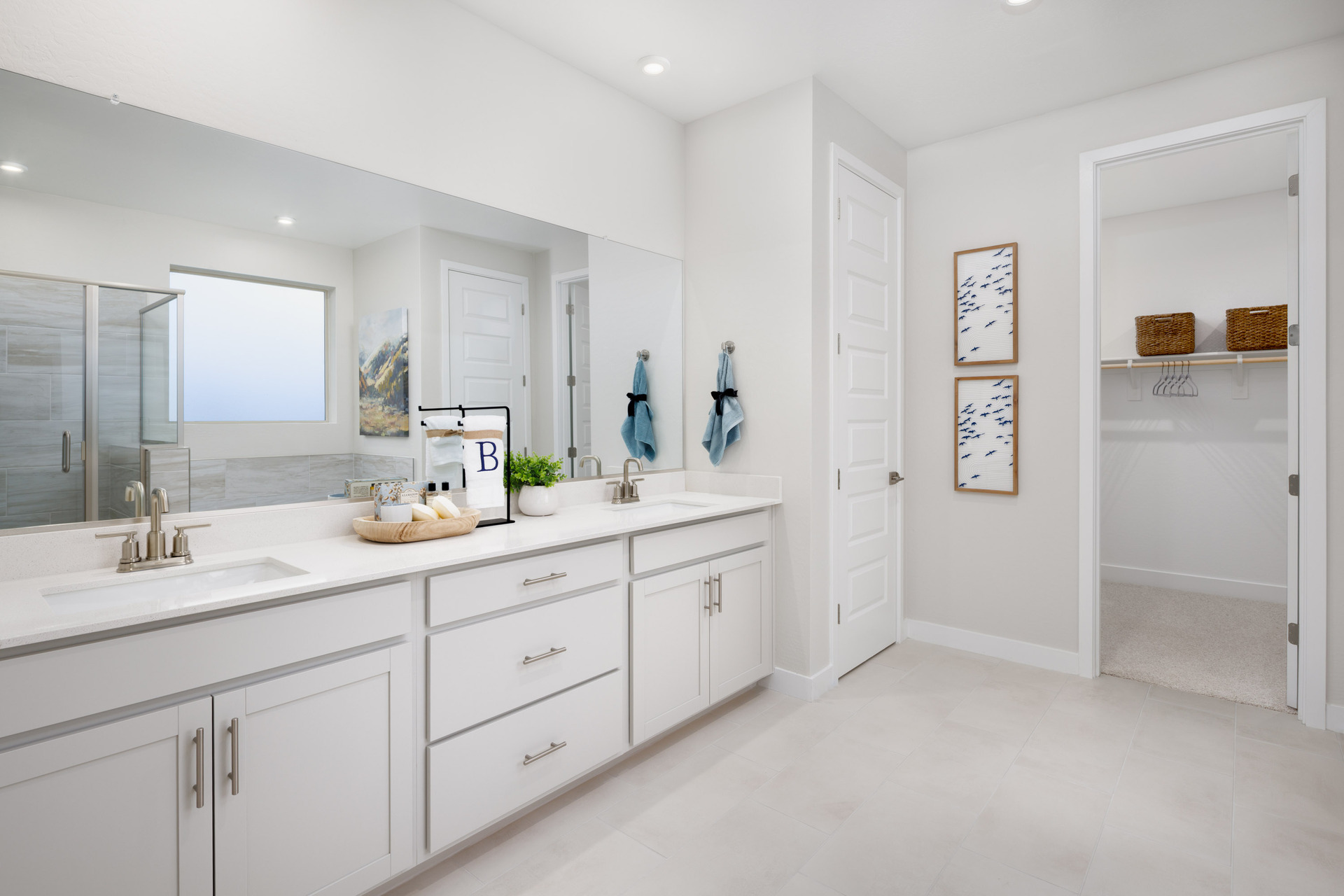 bathroom with light grey cabinets, double sink, and brushed nickel faucets