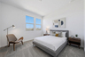 bedroom with a large bed, a grey bedframe, and walnut nightstands
