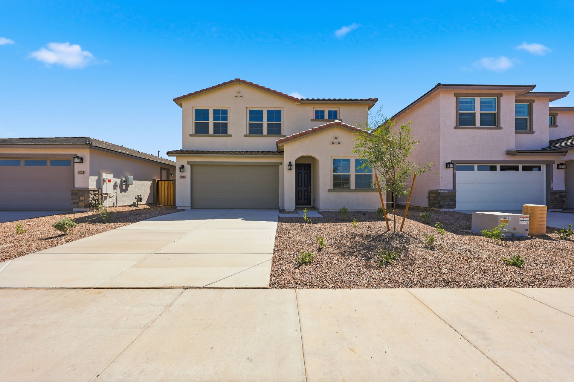 two-story single-family home with desert landscaping and concrete driveway