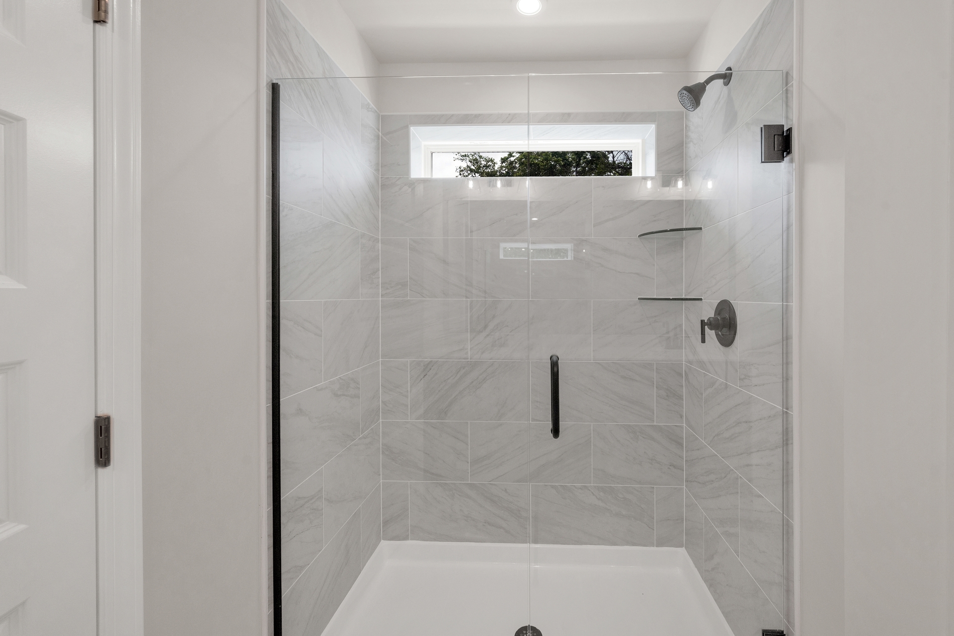 tile walk-in shower with glass doors