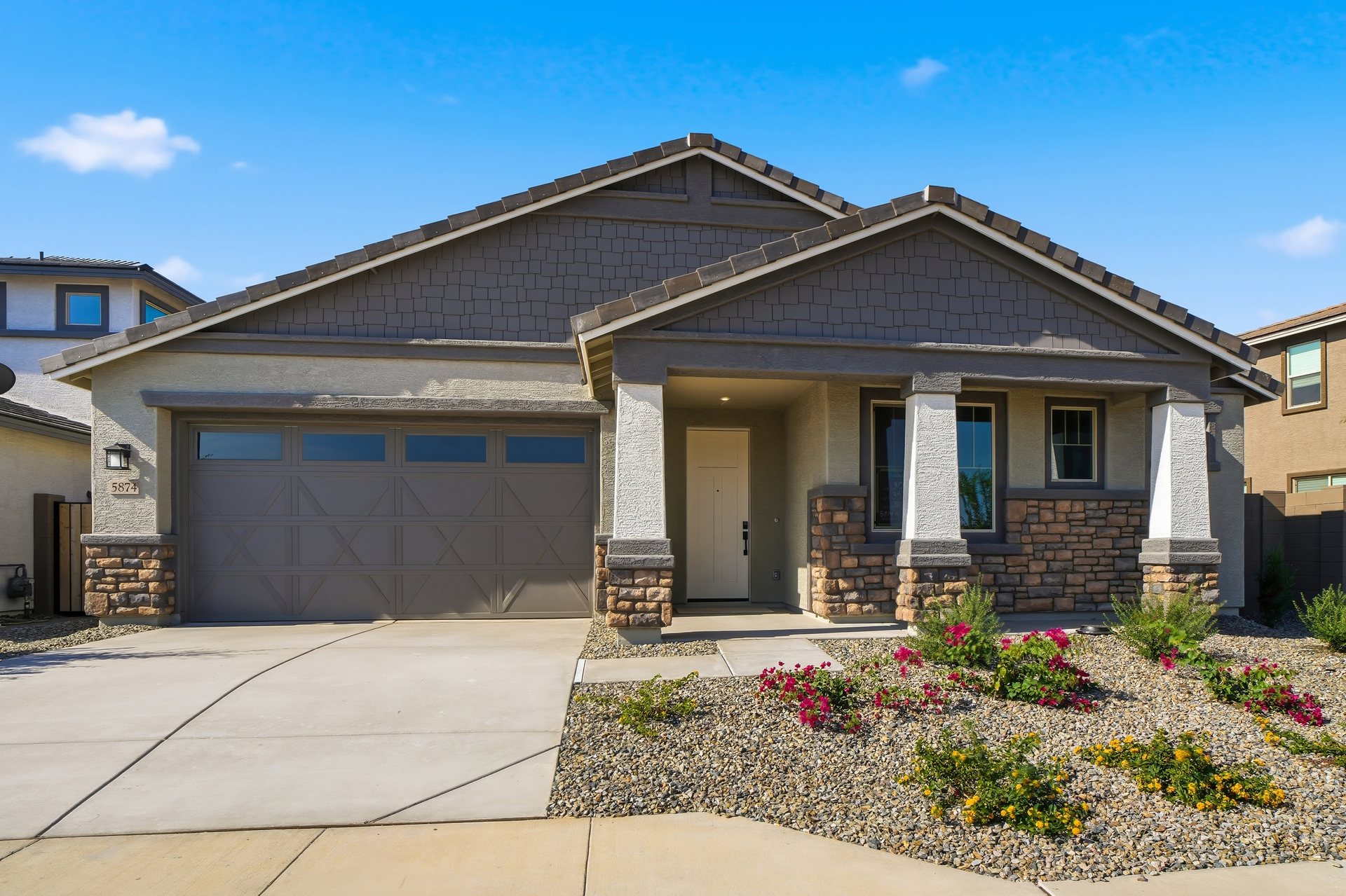 single-story single-family home with a concrete driveway and desert landscaping