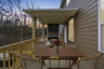 covered patio with outdoor fireplace, dual level decks, and outdoor furniture