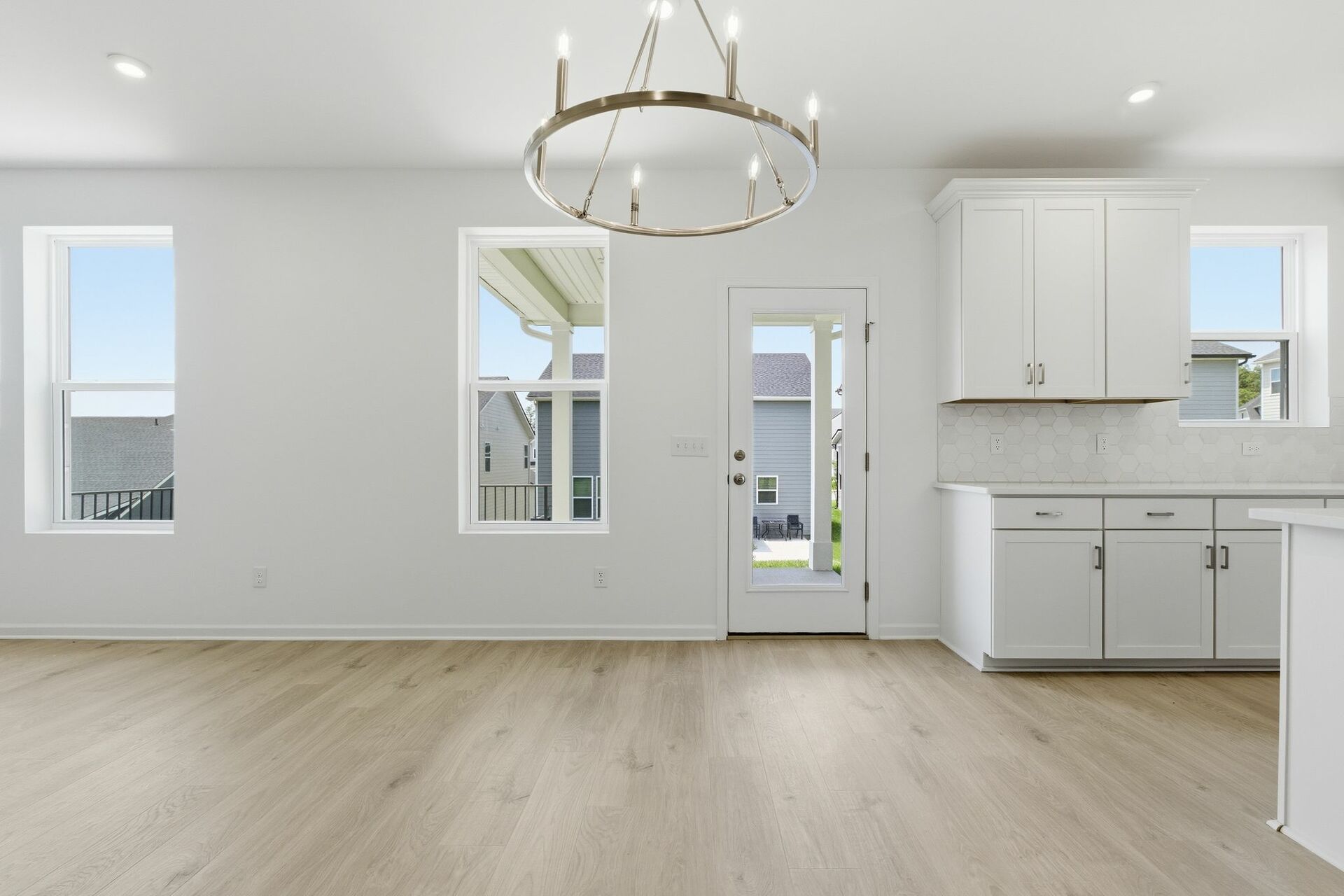 dining room with wood floors, large windows, and accent chandelier