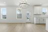 dining room with wood floors, large windows, and accent chandelier