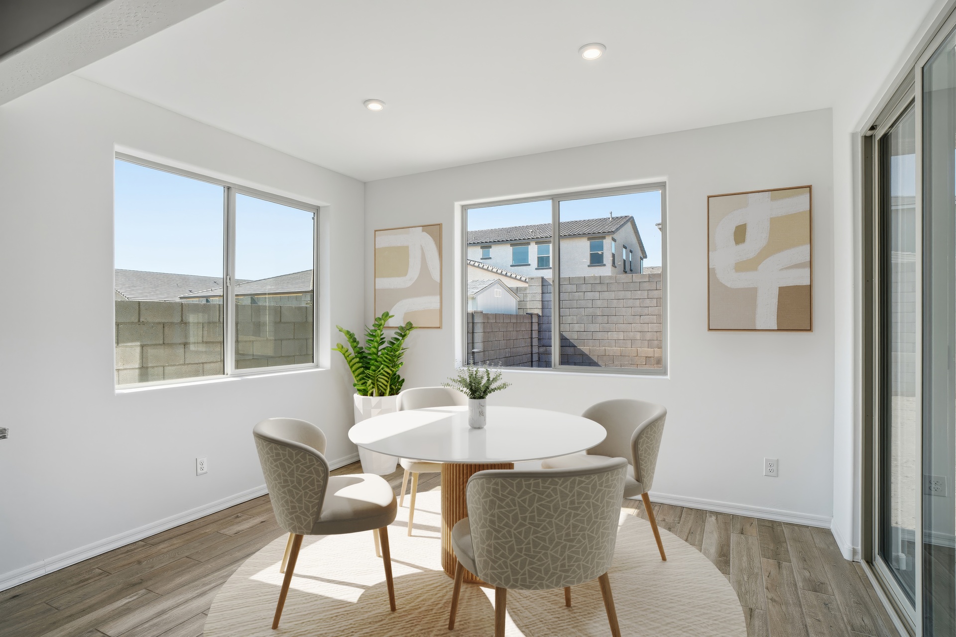 private dining space with beige rug, white round dining table, and beige seats