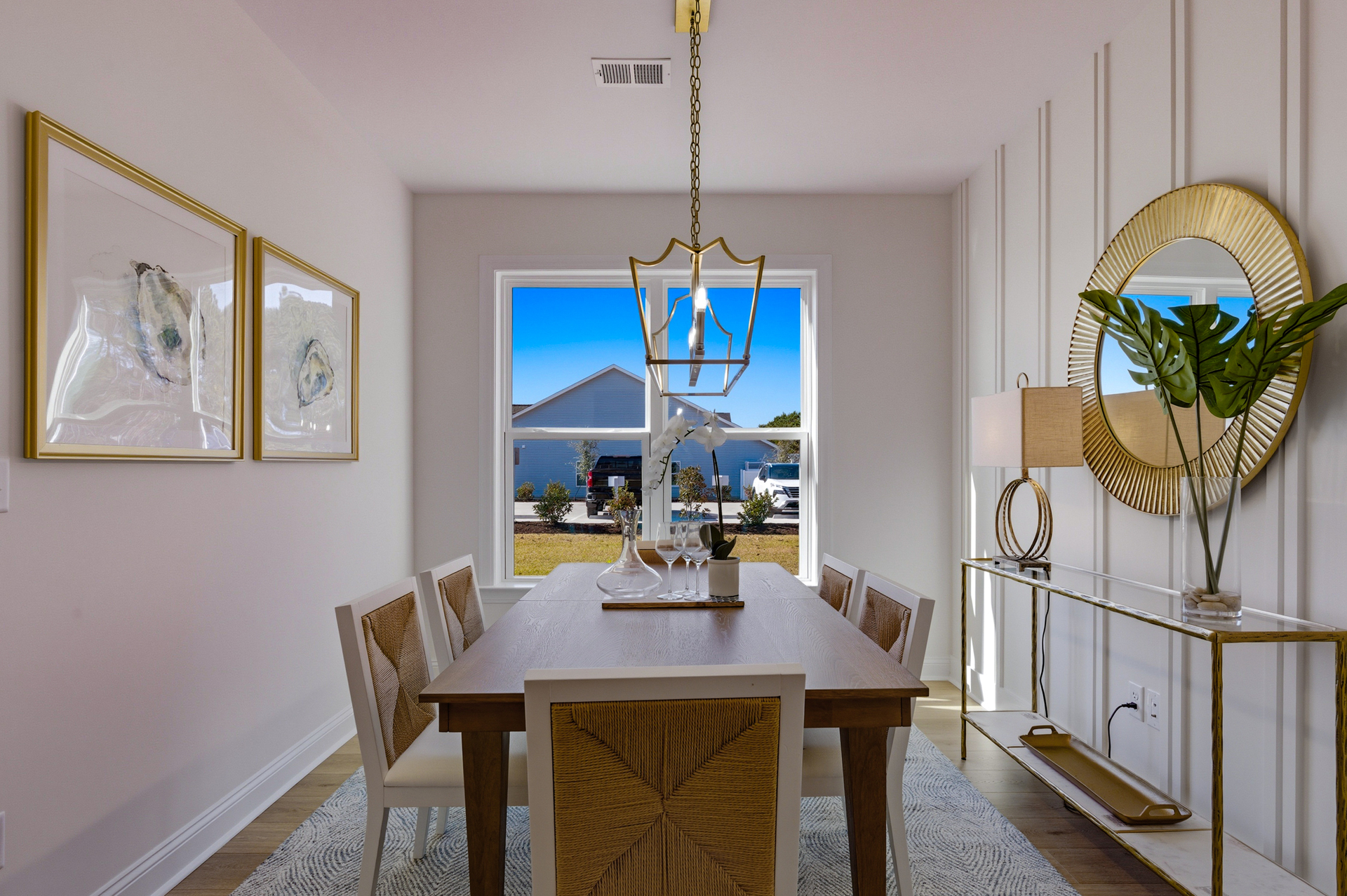 table with 6 chairs and two photos on the wall