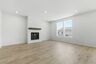great room with white shiplap fireplace, large windows and wood floors