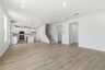 great room with white shiplap fireplace, large windows and wood floors