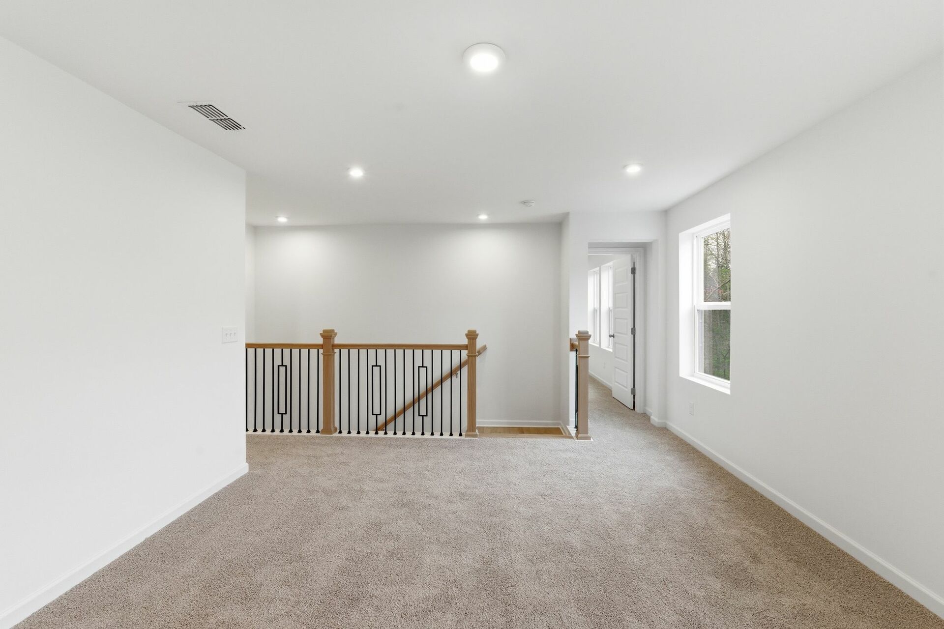 loft space with carpet flooring, white trim, and a window