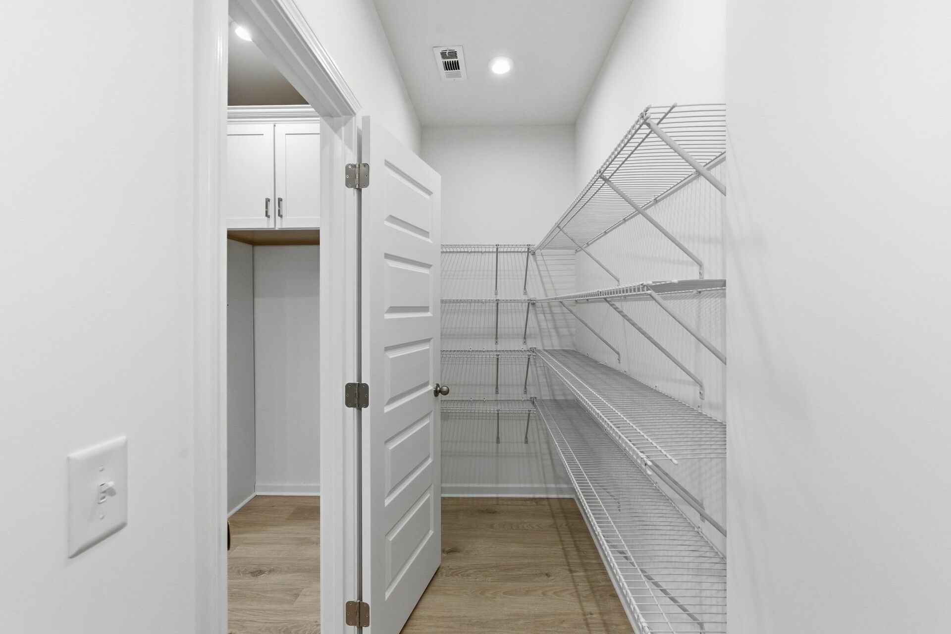 pantry with wood flooring and white wire shelving