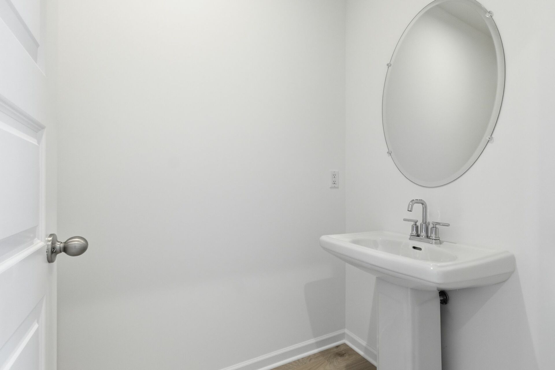 powder room with oval mirror and standing sink