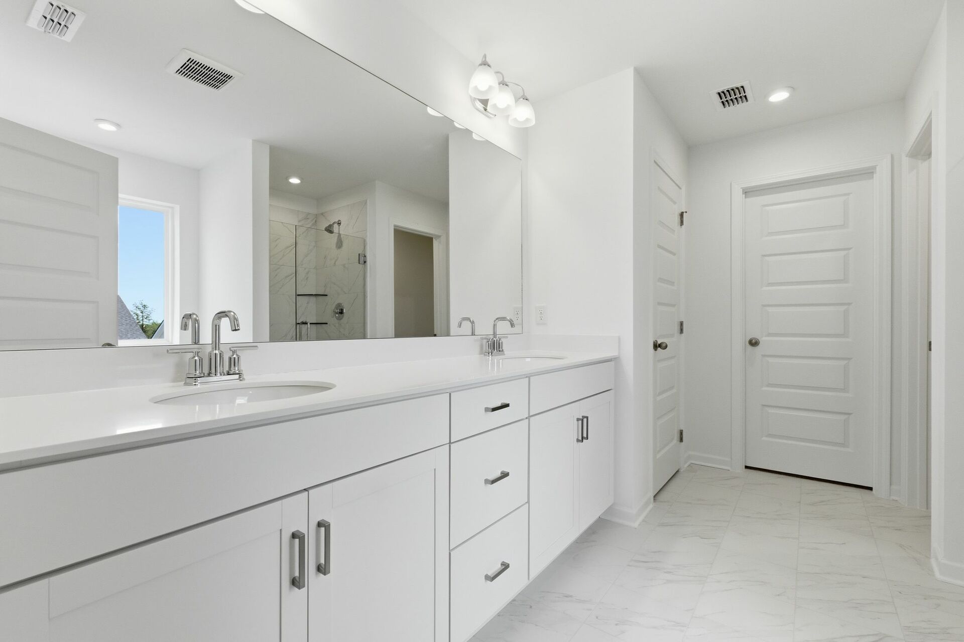 primary bathroom with white cabinets, white sink, large tub and shower