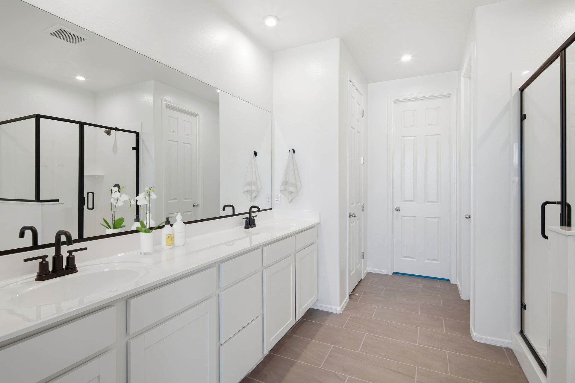 bathroom with white cabinets, walk-in shower and black faucets/hardware