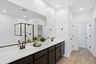 spacious bathroom with black cabinets, black faucets, and white countertops