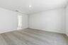 primary bedroom with carpet, large windows, walk in closet and attached bathroom