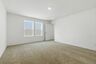 primary bedroom with carpet, large windows, walk in closet and attached bathroom
