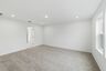 primary bedroom with carpet flooring, white trim, and large windows