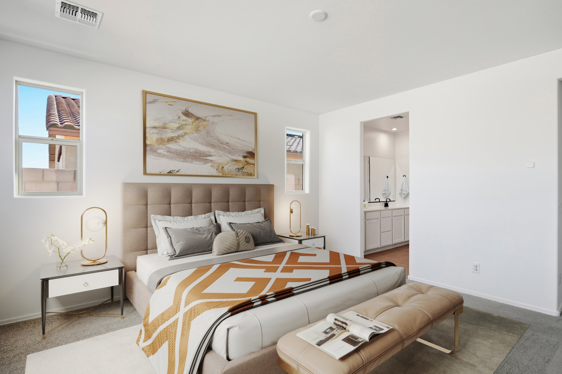 spacious bedroom with large bed with gold/orange accents colors