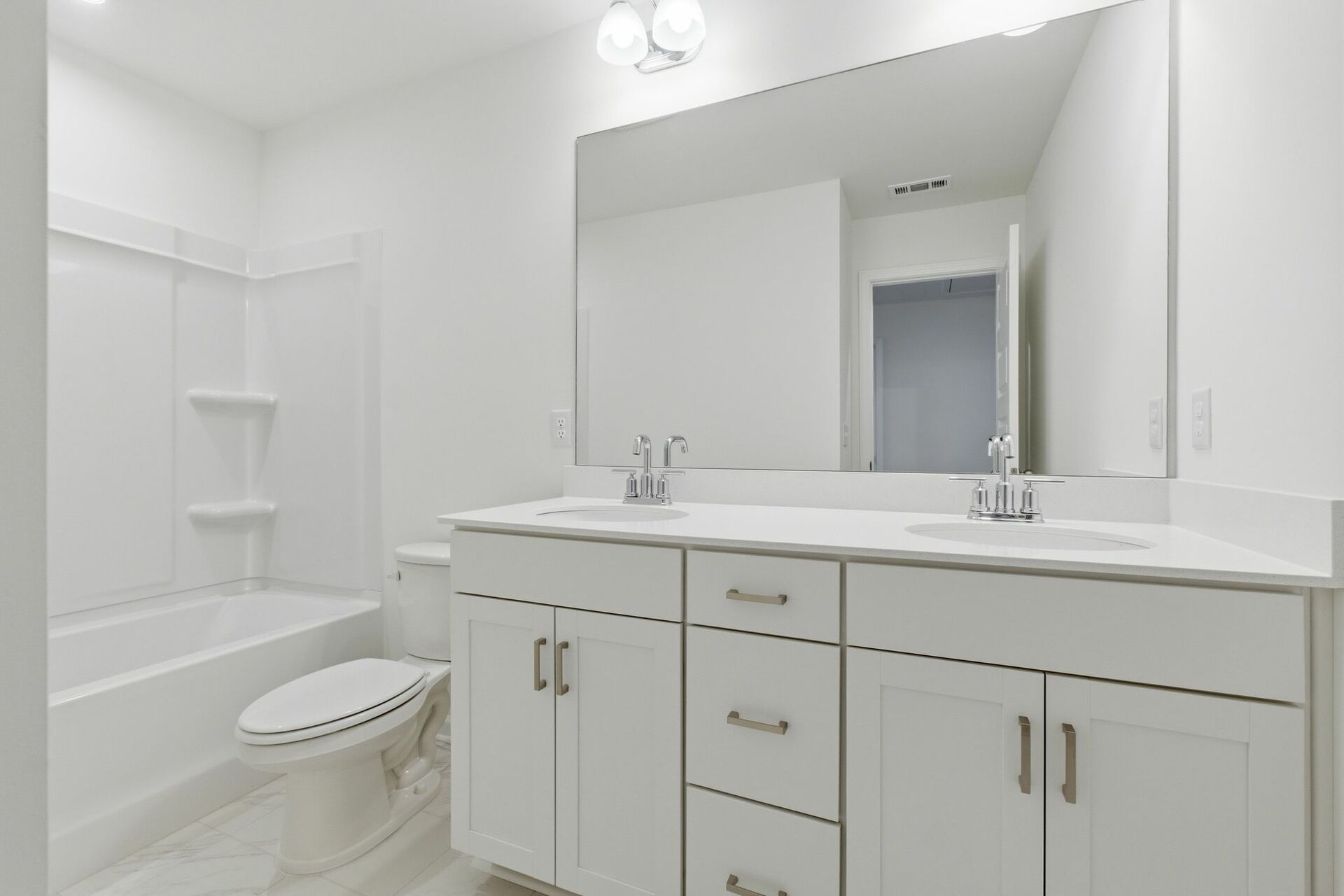 bathroom with tub, dual sink vanity and white cabinets