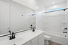 bathroom with black faucets and white cabinets