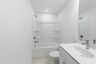 secondary bathroom with white cabinets, tile flooring, and a shower and tub combination
