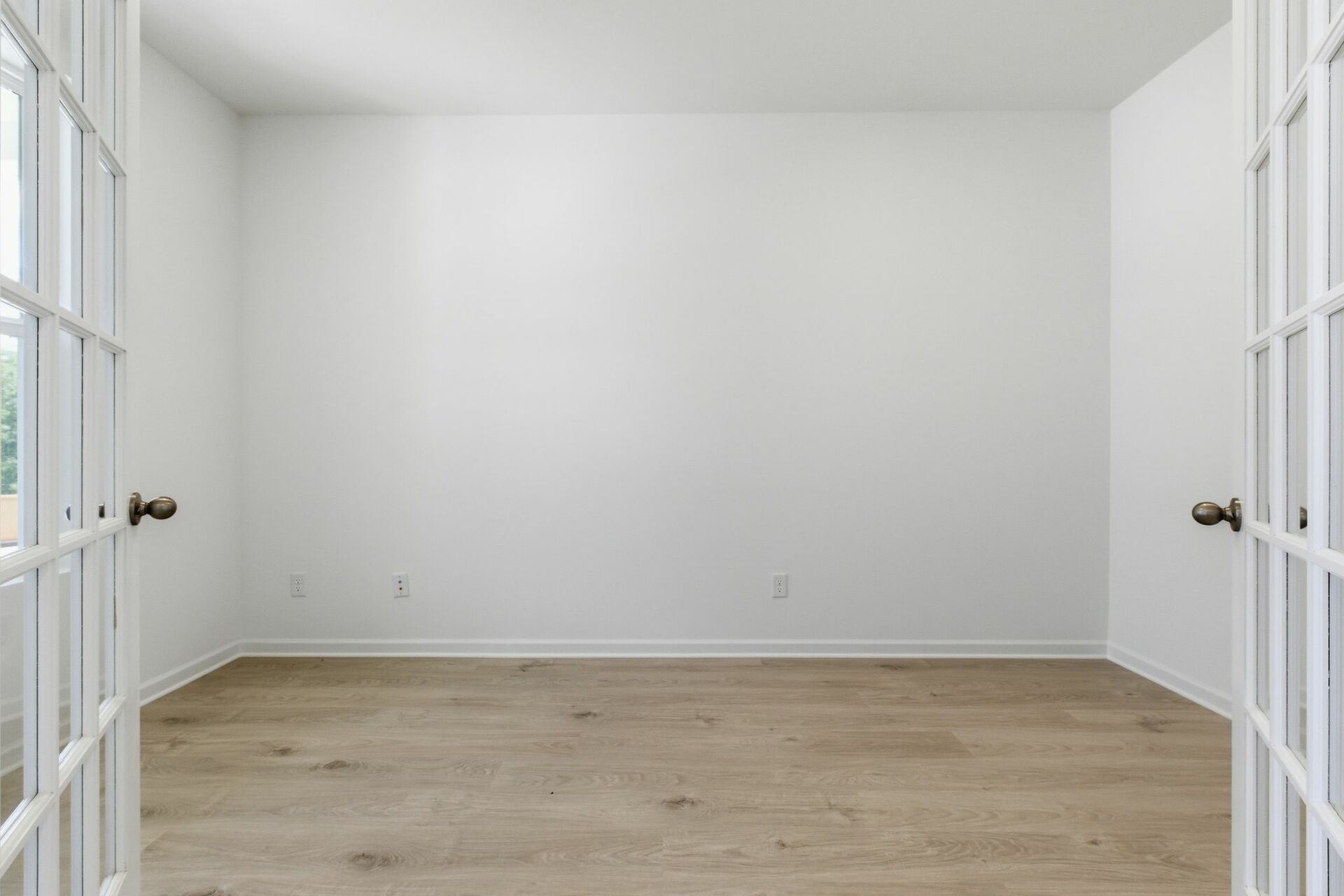 study with large windows, white walls, and french doors