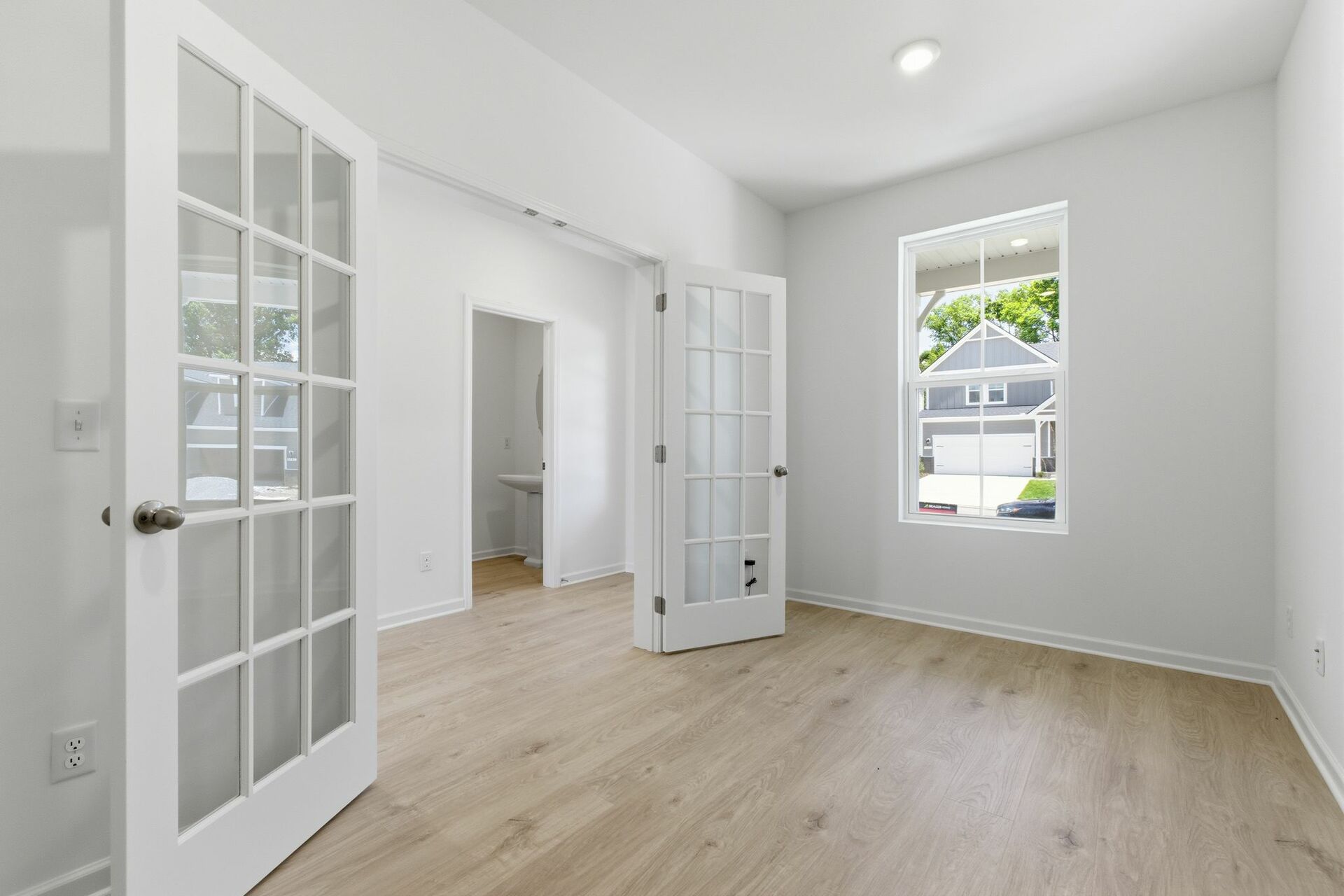study with large windows, white walls, and french doors