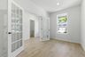 study with large windows, white walls, and french doors