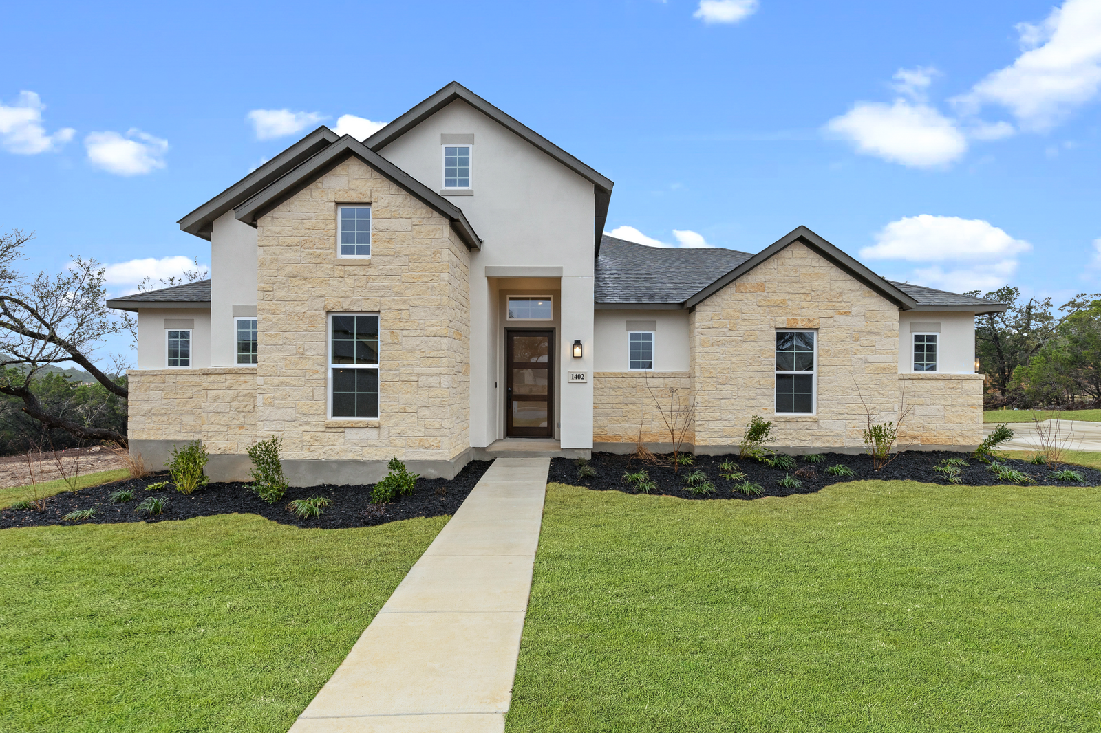 exterior with stucco, stone & grass