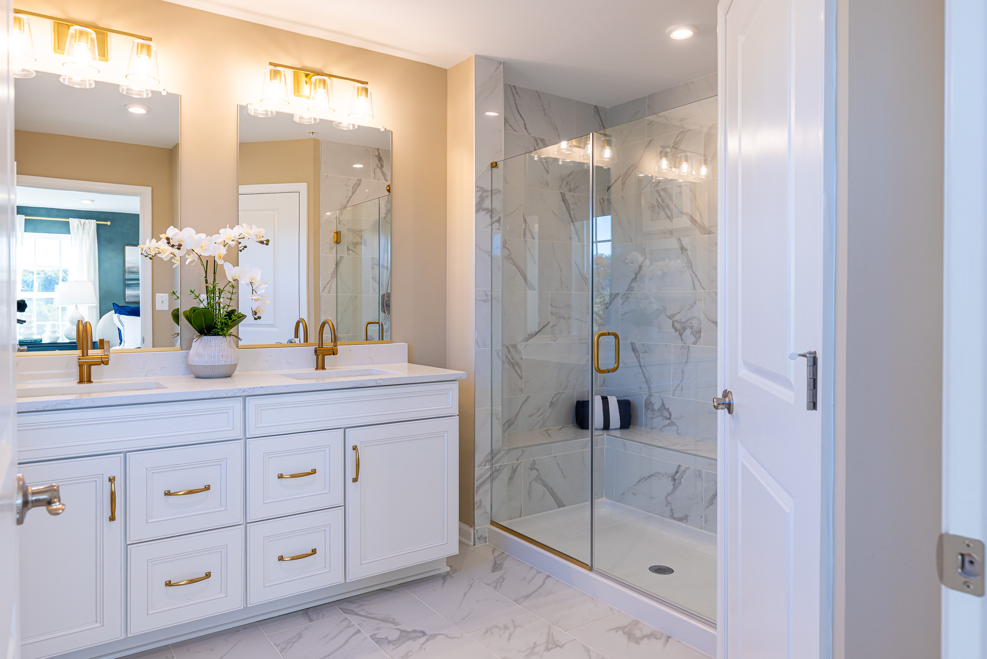 primary bath with dual vanities and a large walk-in shower