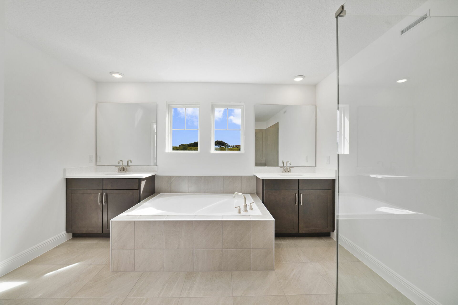 dual vanity with sinks, large windows, shower and tub