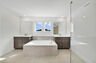 dual vanity with sinks, large windows, shower and tub