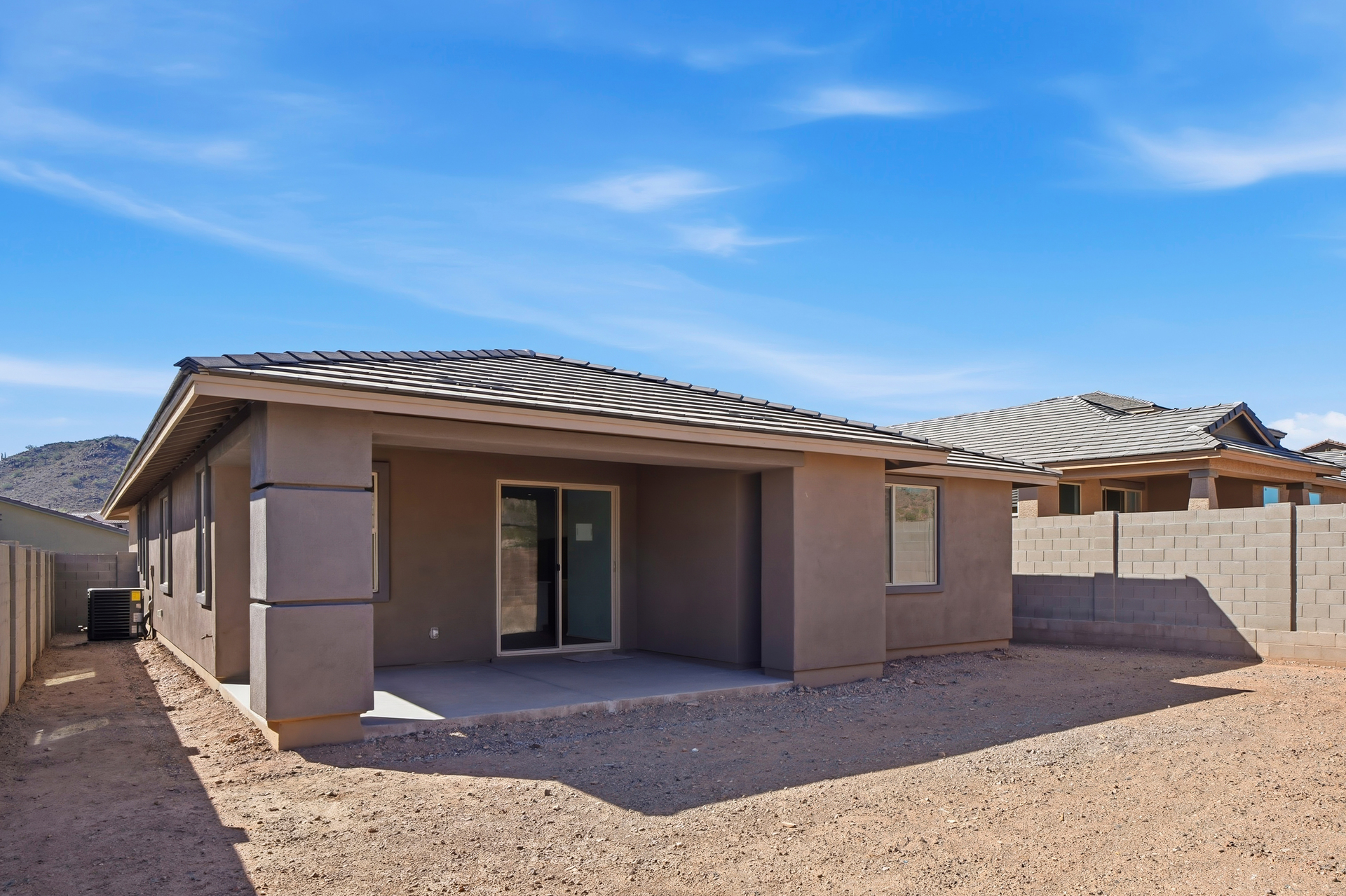 spacious dirt backyard with concrete block wall