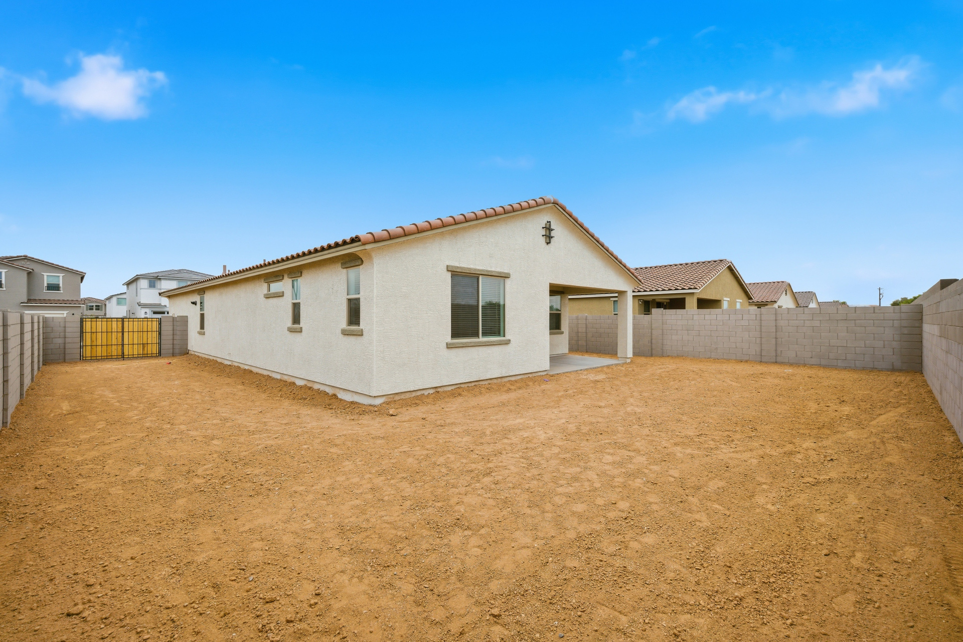 spacious dirt backyard with a double gate for extra backyard storage