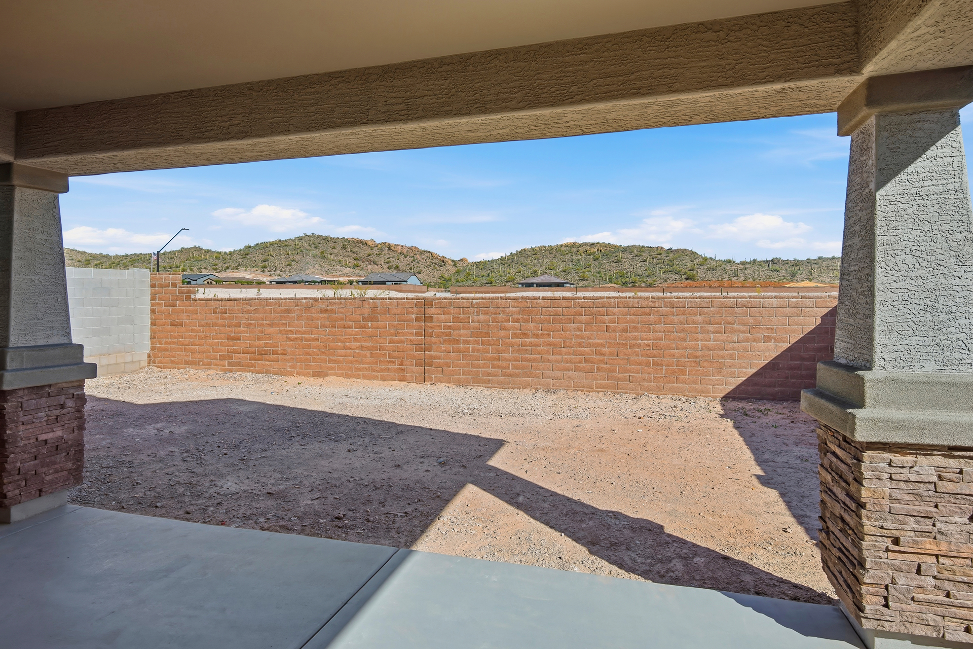 spacious backyard with a concrete and brick block wall