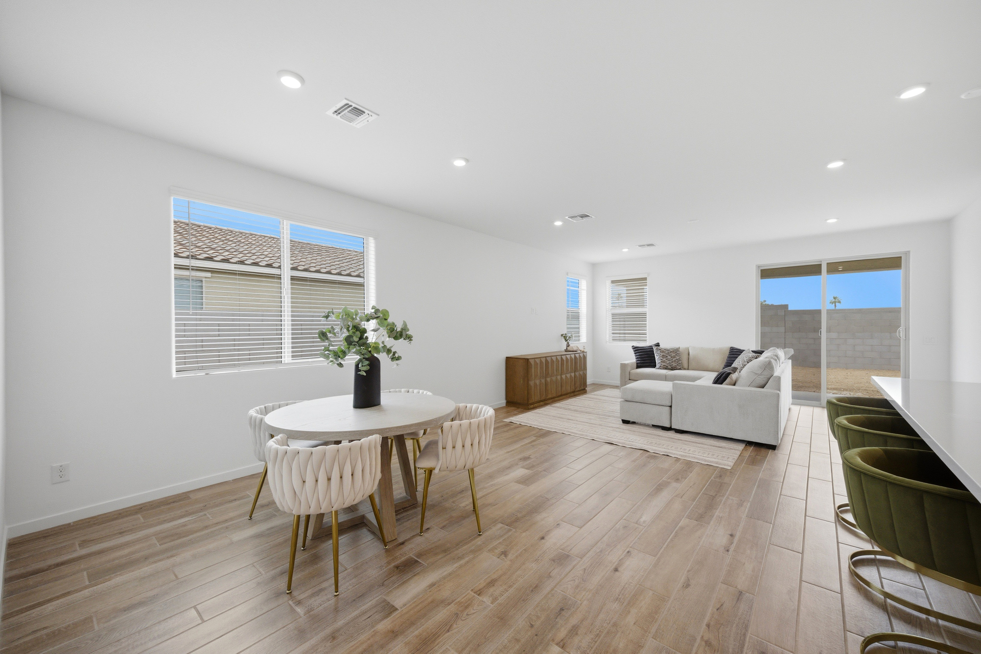 open-concept dining space with wood-like flooring, a round dining table, and white chairs