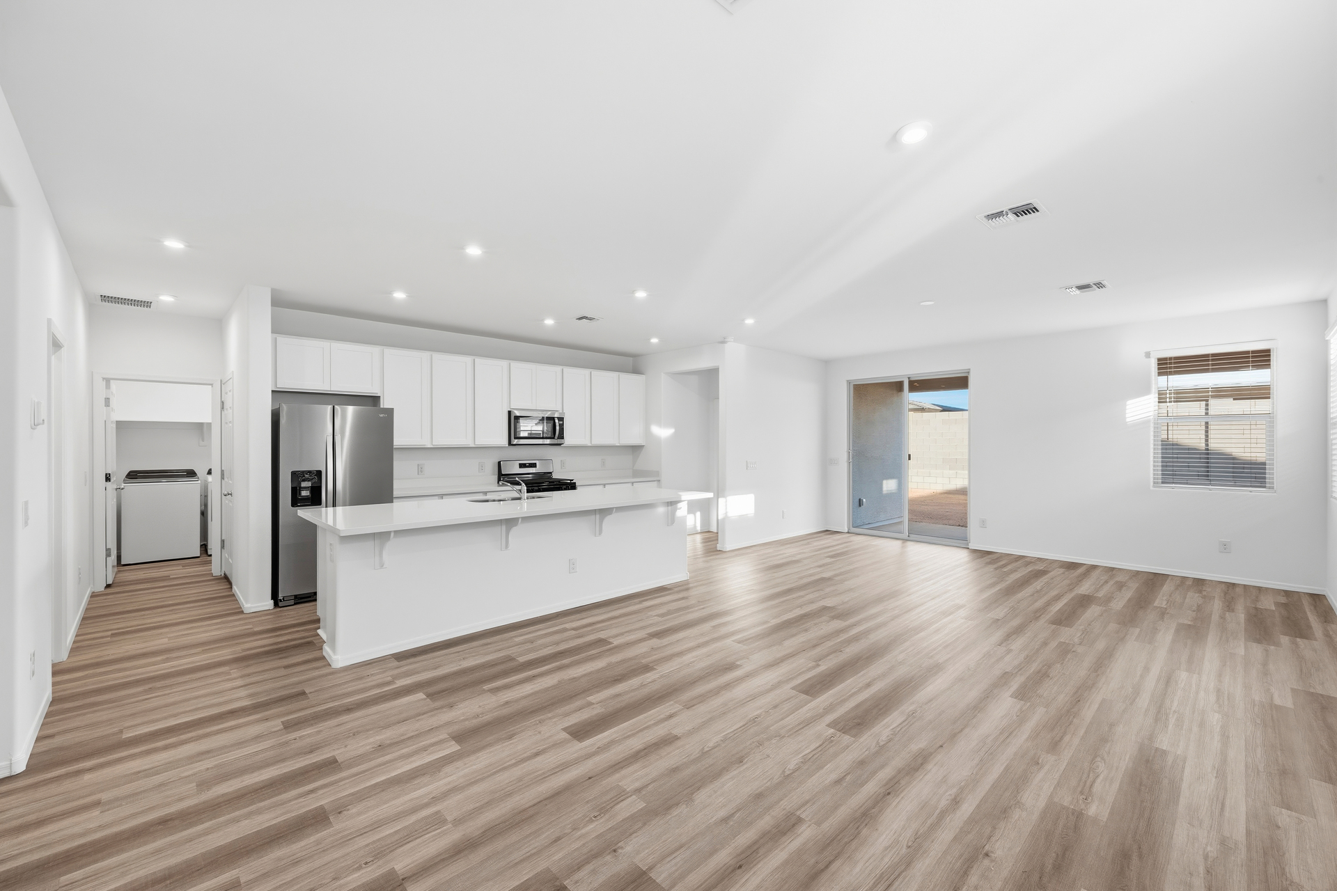 open-concept space with wood-like flooring and quick access to the kitchen