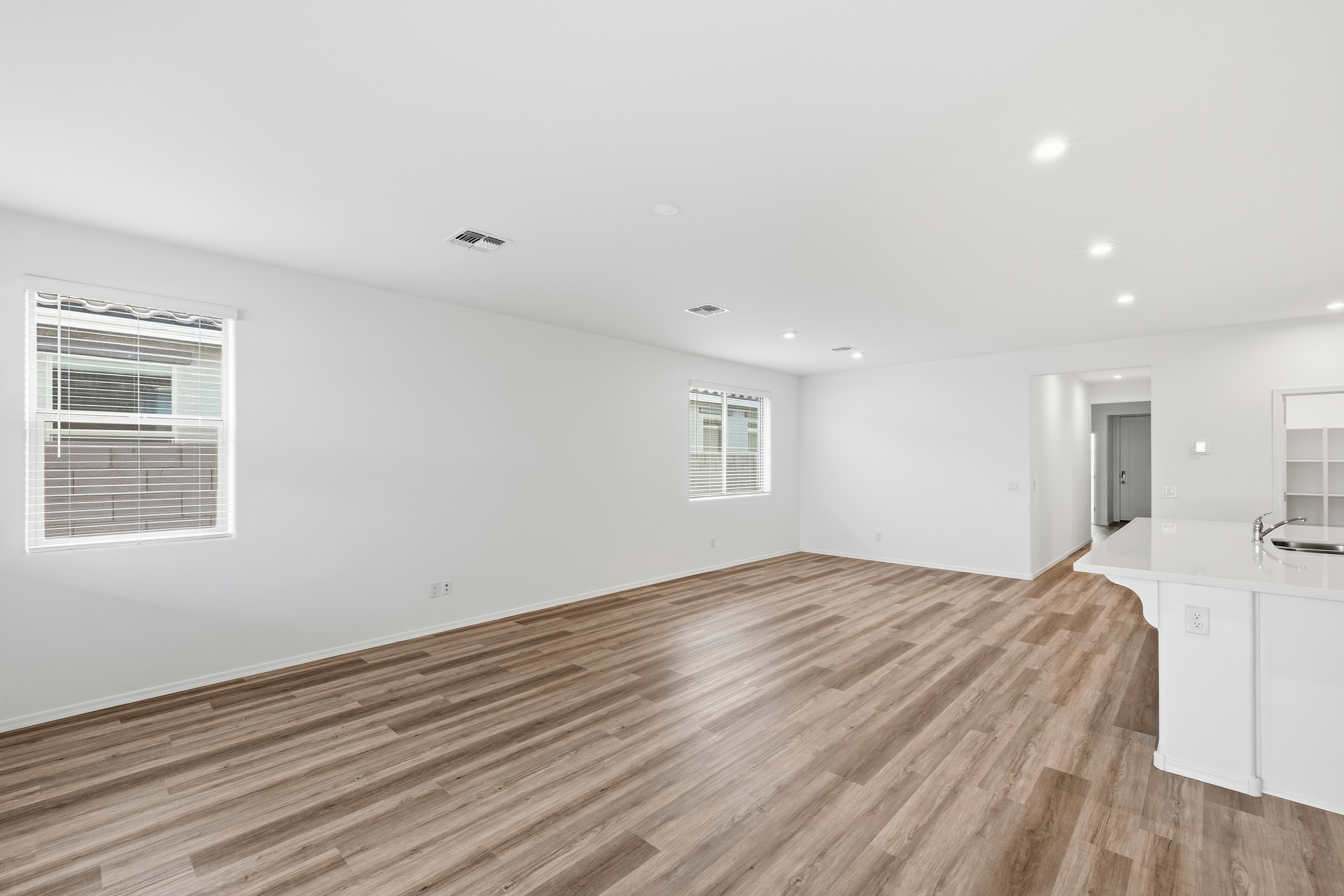 open-concept space with wood-like flooring and quick access to the kitchen
