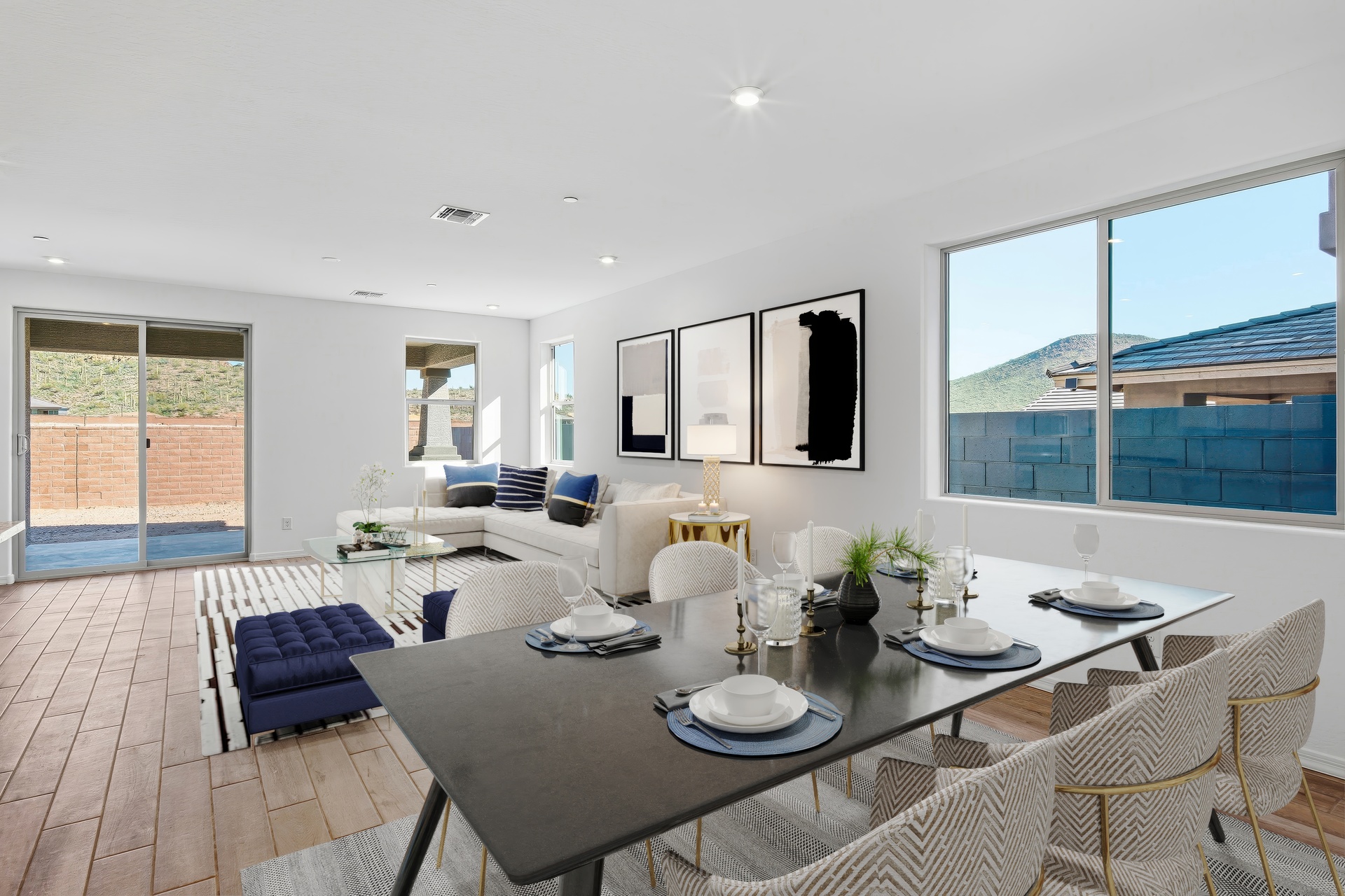 open-concept dining space with a black wooden table and white dining chairs