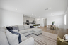 open-concept space with a large grey sectional, white rug, and wooden tv console table