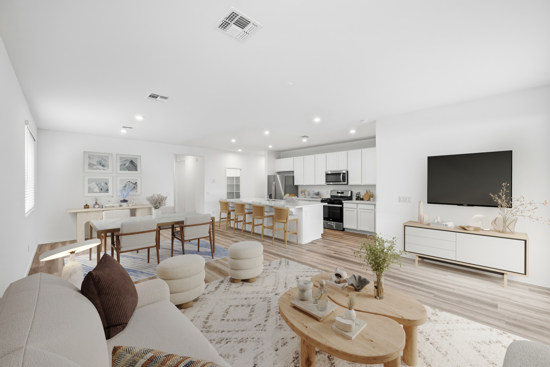 open-concept space with large white couch, wooden coffee table, and white rug