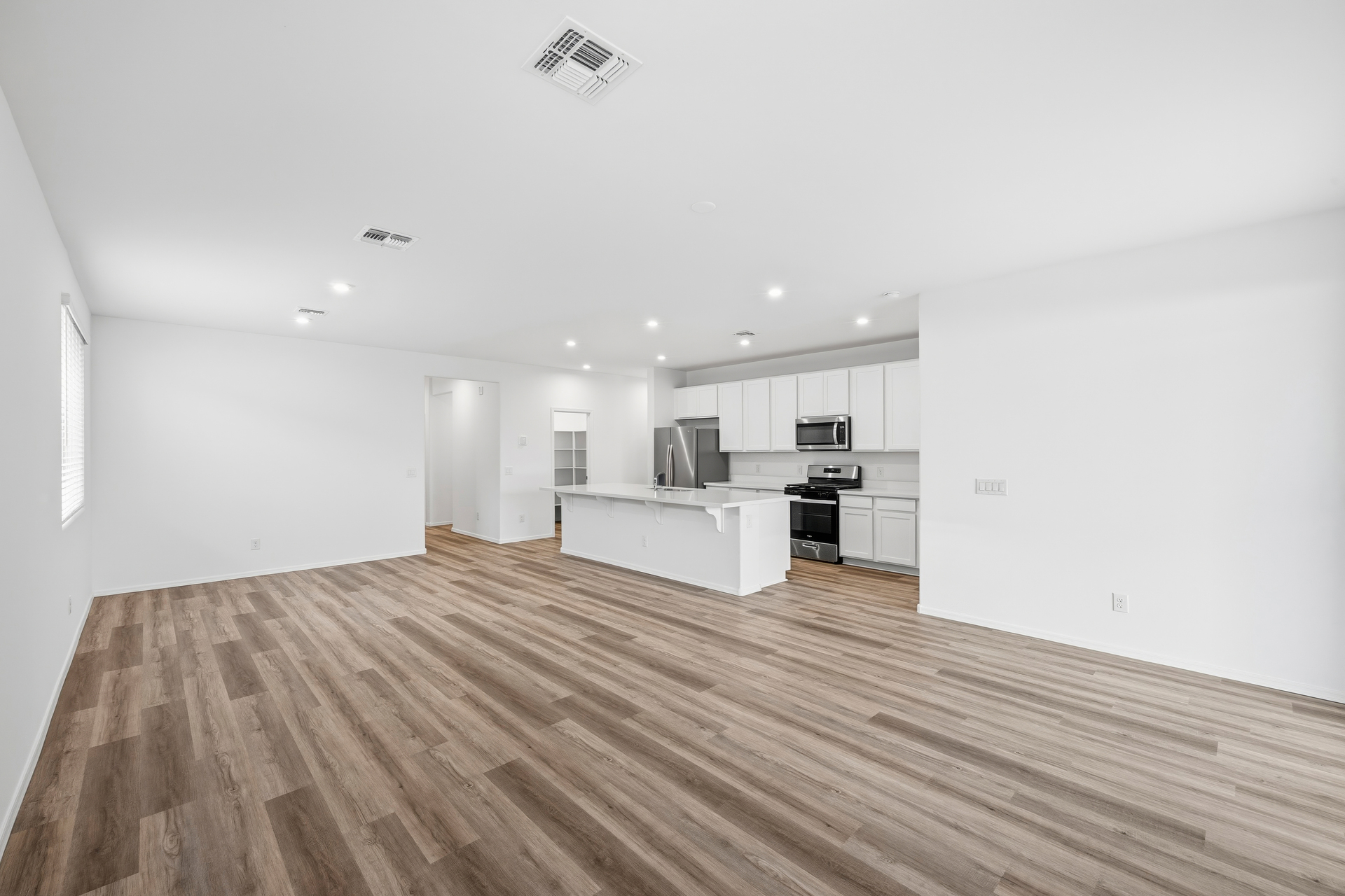 open-concept space with wood-like flooring and recessed lights