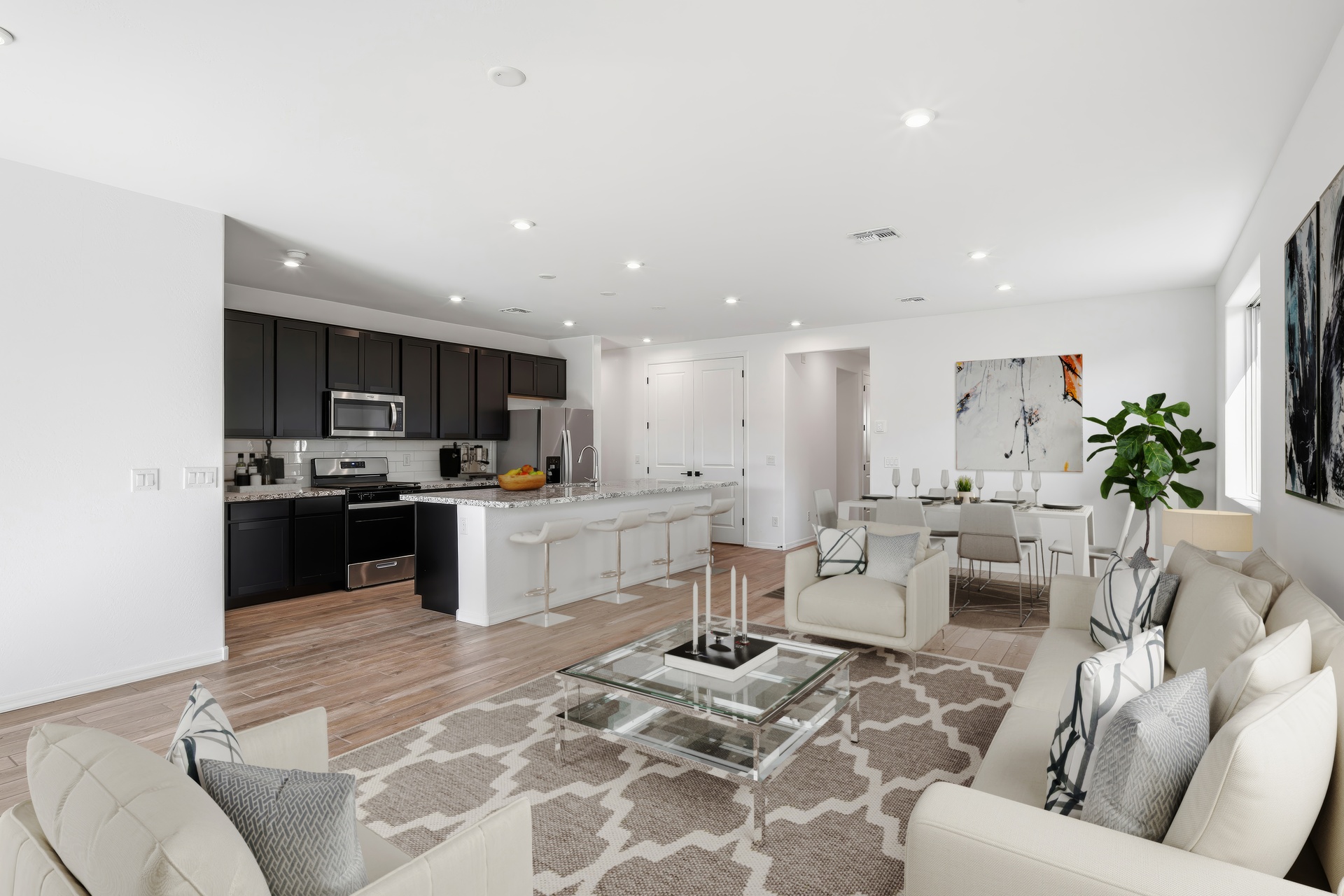 open-concept space with large white couch, glass coffee table and indoor plant