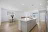 open-concept space with wood-like flooring, dining table, and brushed gold faucet