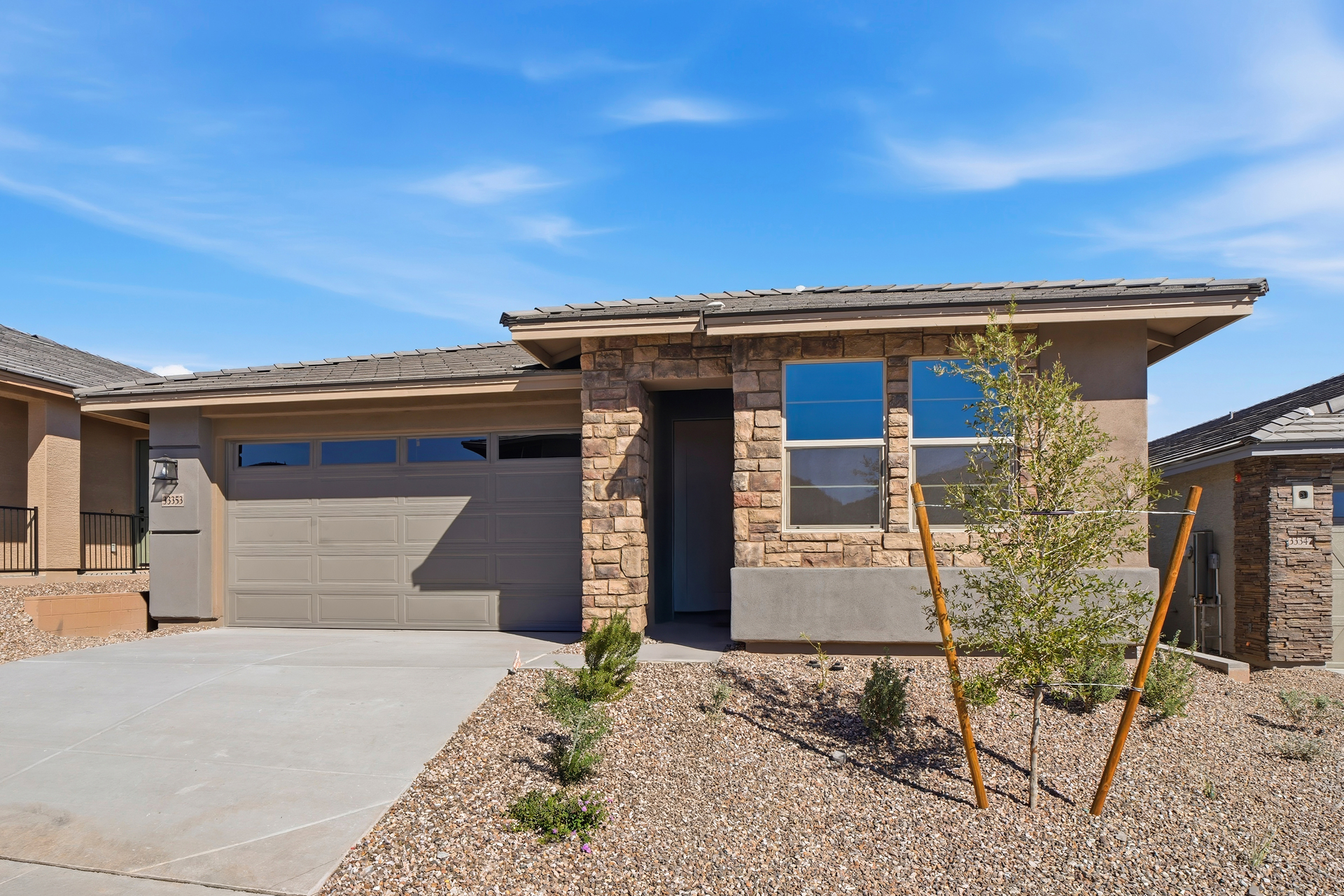 single-story single-family home with concrete driveway and desert landscaping