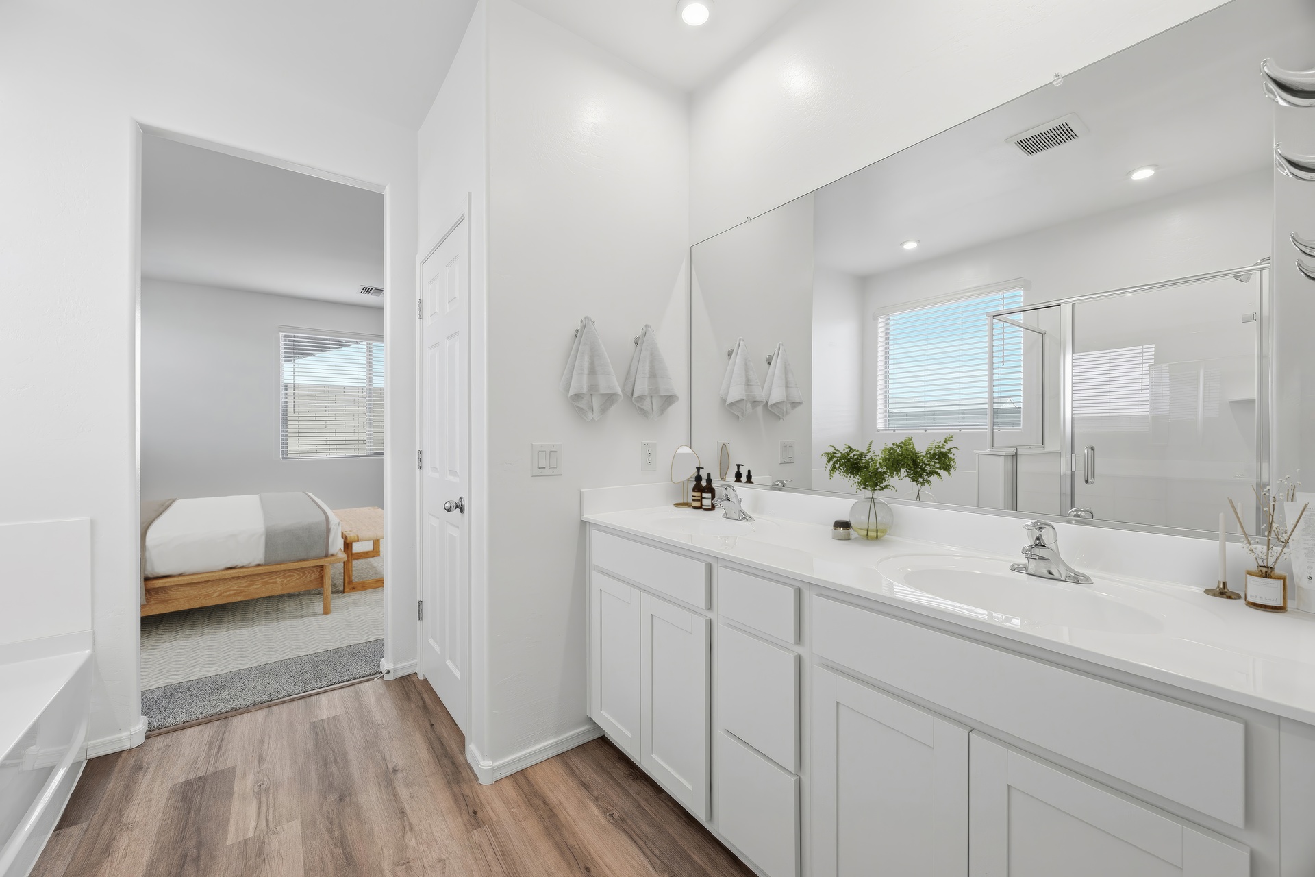 bathroom with white cabinets and views of the bedroom