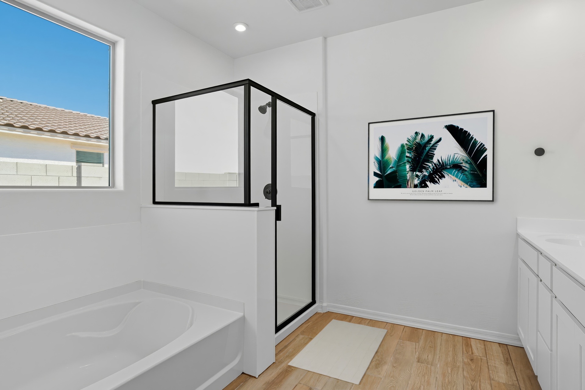 spacious bathroom with wood-like flooring, walk-in shower and soaking tub
