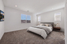 spacious bedroom with a king-sized bed, walnut wooden nightstands, and a mounted tv