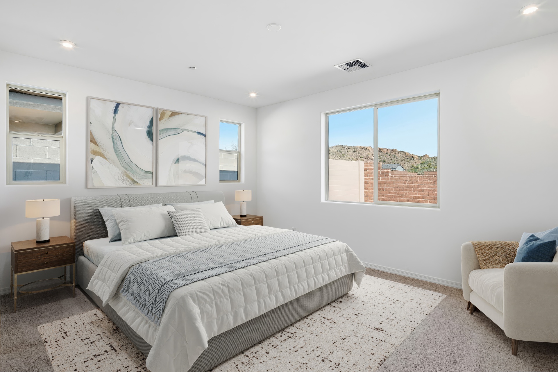 spacious bedroom with a large white bed and wooden nightstands