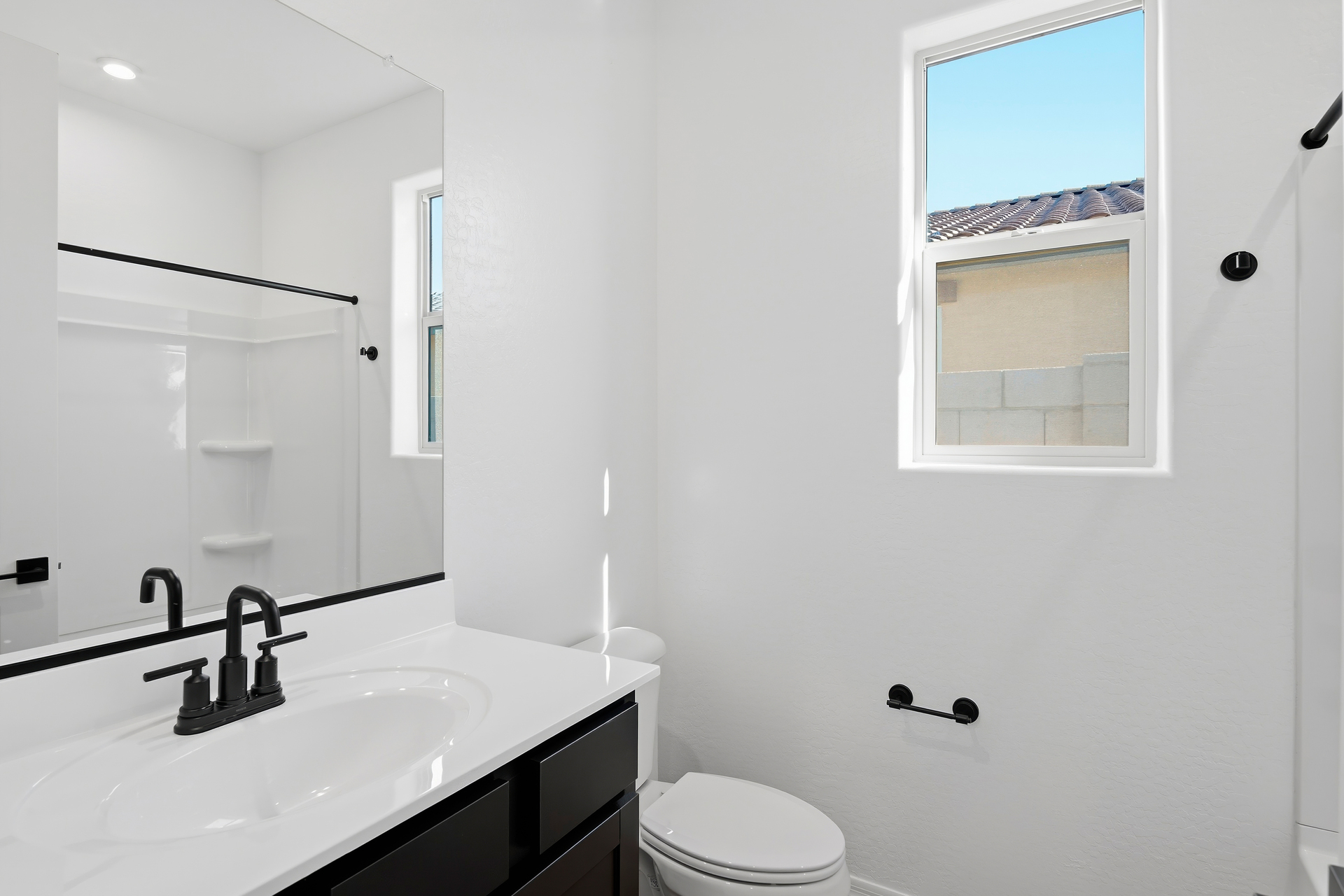 bathroom with black cabinets and black faucet